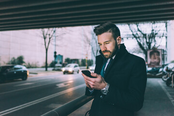 Young contemporary businessman using smart phone