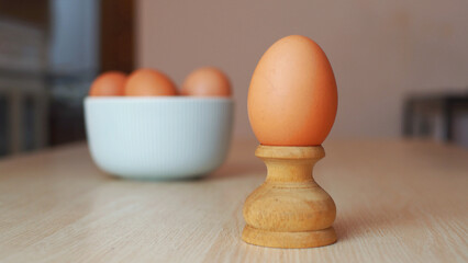 An egg on wood stand with a blurry background