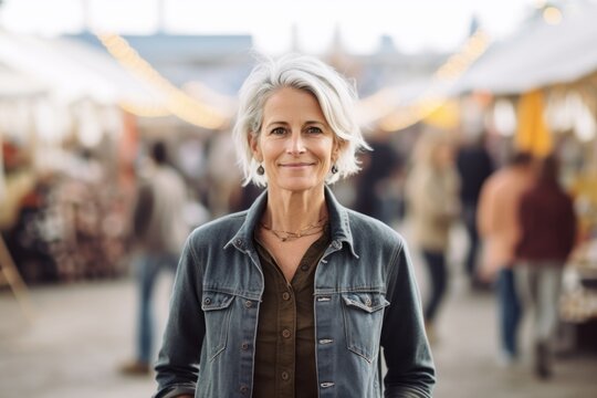 Lifestyle portrait photography of a glad mature woman wearing comfortable jeans against a bustling art fair background. With generative AI technology
