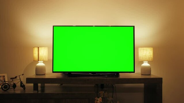 LcD smart TV screen with a blank green background in the living room. Chroma key screen for advertising.