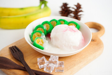 Es Pisang Ijo, traditional dessert from Makassar, South Sulawesi, Indonesia, made from banana which is rolled with a mixture of wheat flour, rice flour and coconut milk. Served with pureed and syrup