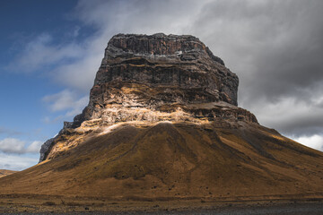 Icelandic landscape with big hill and dramatic clouds. Low angle photo - obrazy, fototapety, plakaty