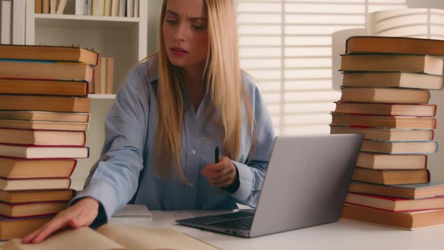 Stressed busy annoyed Caucasian student girl high school pupil woman stressful leaner studying with laptop and books homework prep to exams learning online search information e-learning difficulties