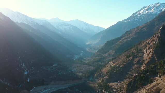 Cinematic Sunlight Coming Through Sky Between Himalayan Mountains, Spiti Valley in India Aerial Drone View, Light Blue and Golden Morning Panorama