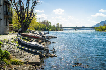 Buildings of the city of Lecco on the banks of the river Adda. Bridges and an island with mountains in the background
