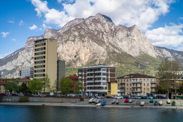 Buildings of the city of Lecco on the banks of the river Adda. Bridges and an island with mountains...