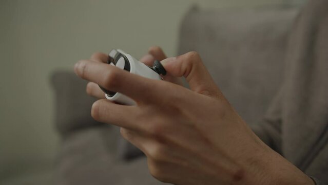 Black Hands Using Joystick for Video Game. 20s male playing video game sitting on couch at home. 