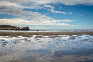 surfista dirigiéndose al mar en la playa de Salinas, Asturias, España