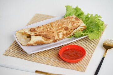 Kebab, tortilla wrap with fried chicken meat and vegetables served on white plate, isolated on white background