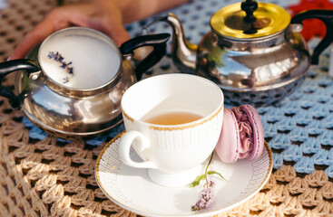 Cake macaron on the background of a cup of tea