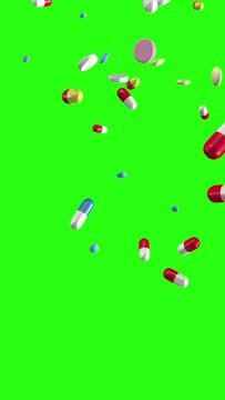 Pills and capsules falling on a chroma key greenscreen background. Loop section from 10:00 to 20:00. Vertical video. Medicine, medical, pharmaceuticals.