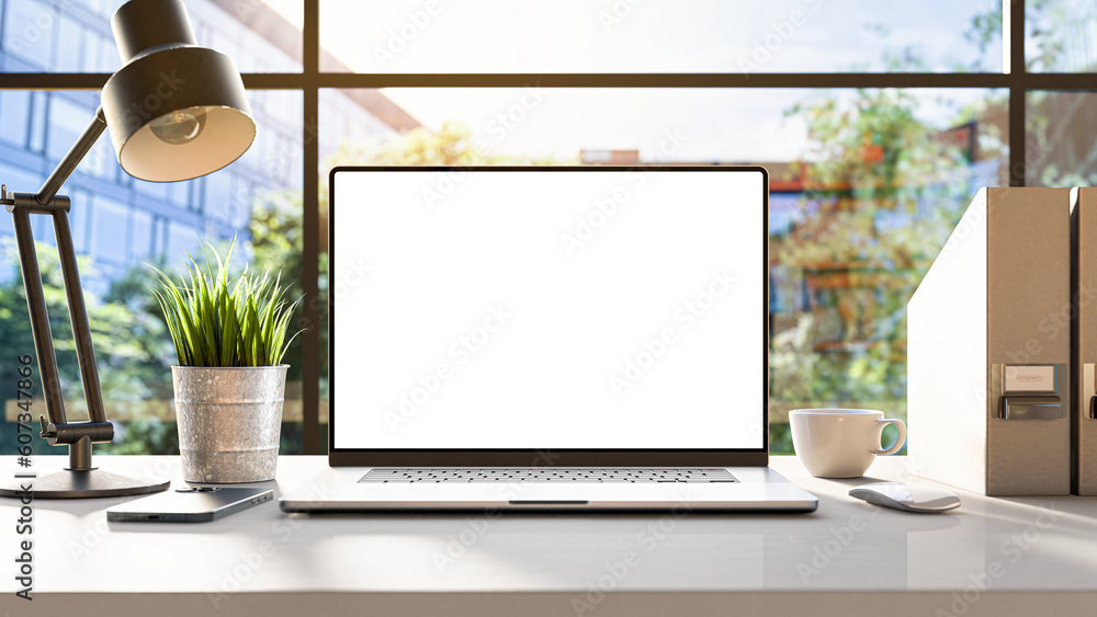 Poster a laptop with a blank frameless screen mockup template is positioned on a table in an office interio