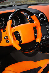 View of the interior of a modern automobile showing the dashboard. Tuning. Orange luxury car