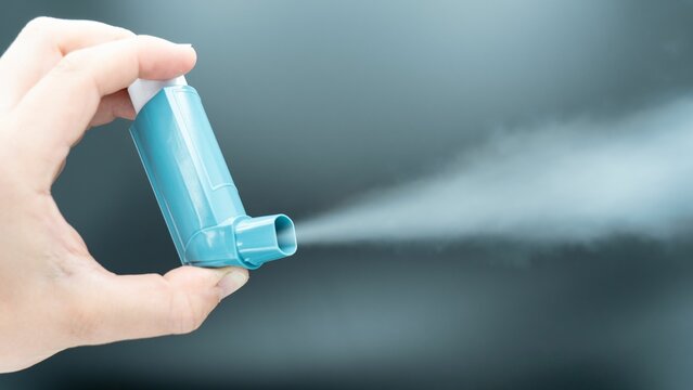 Hand holding an asthma inhaler