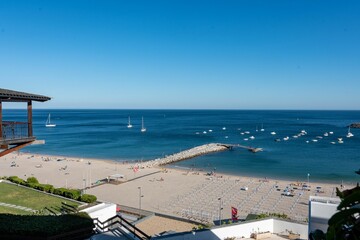 Fototapeta na wymiar Aerial view of a Sesimbra sea beach with a pier in Portugal