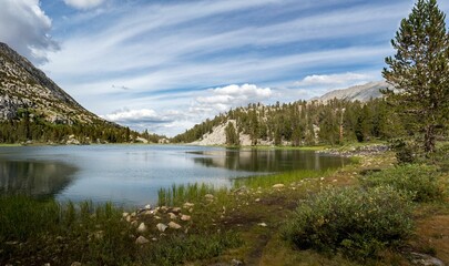 Panoramic shot of a Mammoth mountain lake with trees and mountains in the background