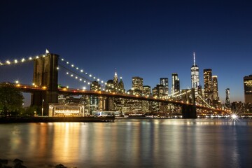 Fototapeta na wymiar Scenic shot of the lights on the bridge and skyline of Manhattan in New York during nighttime