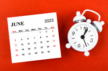 The June 2023 Monthly calendar year with alarm clock on red background.