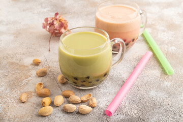 Bubble tea with pistachio and caramel in glass on brown concrete, Side view.