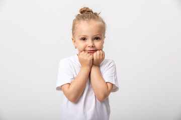 Smiling cute little blonde girl in white t-shirt isolated on white background. Copy space. Mock up
