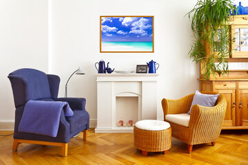 Custom-made home decoration concept: living room with a wing and a wicker chair and a framed photo print of a beautiful caribbean beach scene.