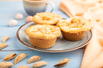 Traditional portuguese cakes pasteis de nata, custard small pies on blue wooden. Side view, selective focus.