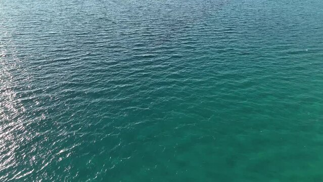 Blue sea with white waves scallops on clear day. Marine background weather in open azure sea. View from ship on waving restless surface of ripples nautical texture. Dark ocean water. 4k