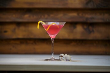 Fruit cocktail in a glass with a lemon twist, wooden background