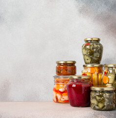 Preserving vegetables for the winter, canned vegetables in jars on a light background, pickled or...