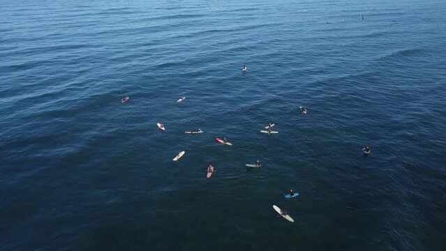 Aerial view over surfers in Pacific Ocean in San Diego with blue sky on the horizon