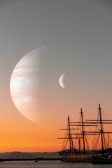 Vertical shot of an old ship without sails before the moon and a planet silhouette