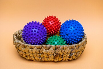View of colorful spikey balls in a basket over the orange background