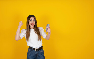 Woman doing winner gesture,  happy young brunette woman doing winner gesture. 20s student girl...