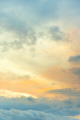 Naklejka na ściany i meble Fotografía vertical del cielo con nubes en la hora del atardecer, con texturas de colores.