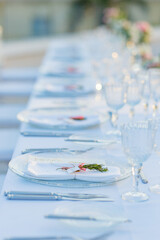 Crystal wineglasses and plates on banquet table