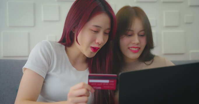 Young asian woman and friend using credit to shopping at home. She buying product in online store together at home.