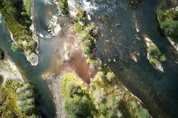 Aerial shot of a river flowing through the trees in Norway.