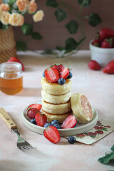 A stack of fluffy pancakes with fresh berries and a hint of honey.