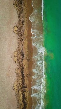 Aerial view of waves hitting the beach during summer
