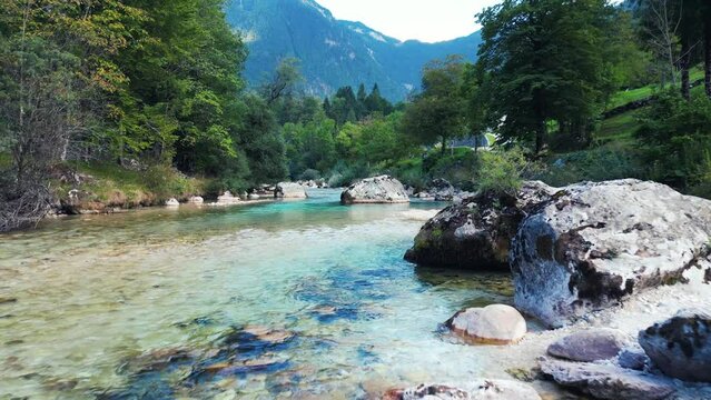 Aerial of the River Soca with crystal clear waters surrounded by the green trees and mountains