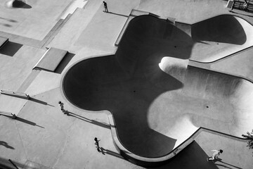 Drone grayscale shot of TX Skaters at the skate park casting long shadows in Austin city