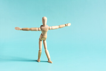 The concept of a wooden mannequin performs physical exercises, leaning forward and spreading his arms to the sides