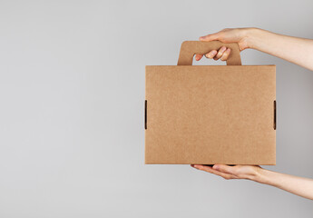 Woman hands holding cardboard box from natural recyclable materials. Responsible consumption, eco friendly packaging, zero waste and sustainable lifestyle concept.