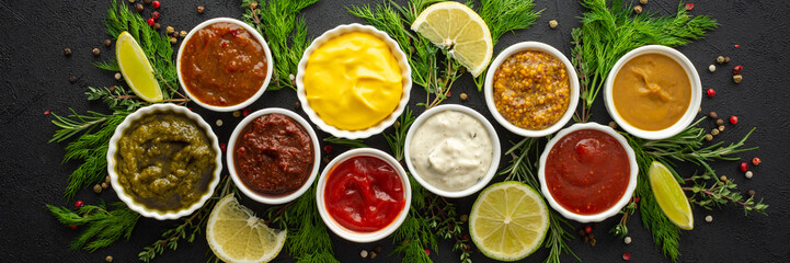 Different types of sauces in bowls with seasonings banner, rosemary and dill, thyme and and peppercorns, top view, copy space