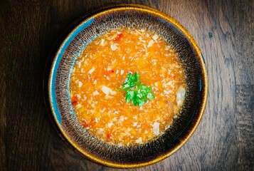 Top view of a bowl of gourmet Asian crab soup on a wooden table