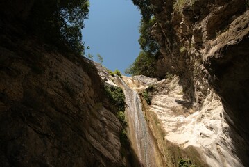 Low-angle of Dimosari waterfalls on Lefkada island sunlit clear sky background