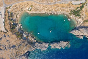 Top aerial of Lindos lake on a sunlit rocky island with a seascape view, Rhodes, Greece