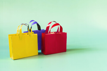 Colored paper bags close-up on a light background copy space. business concept