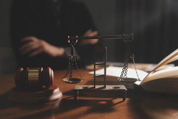 law books and scales of justice on desk in library of law firm. jurisprudence legal education...