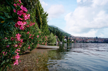 Fototapeta premium Beautiful scene of boat on lake Como in Italy. A big blue lake surrounded by green hill.